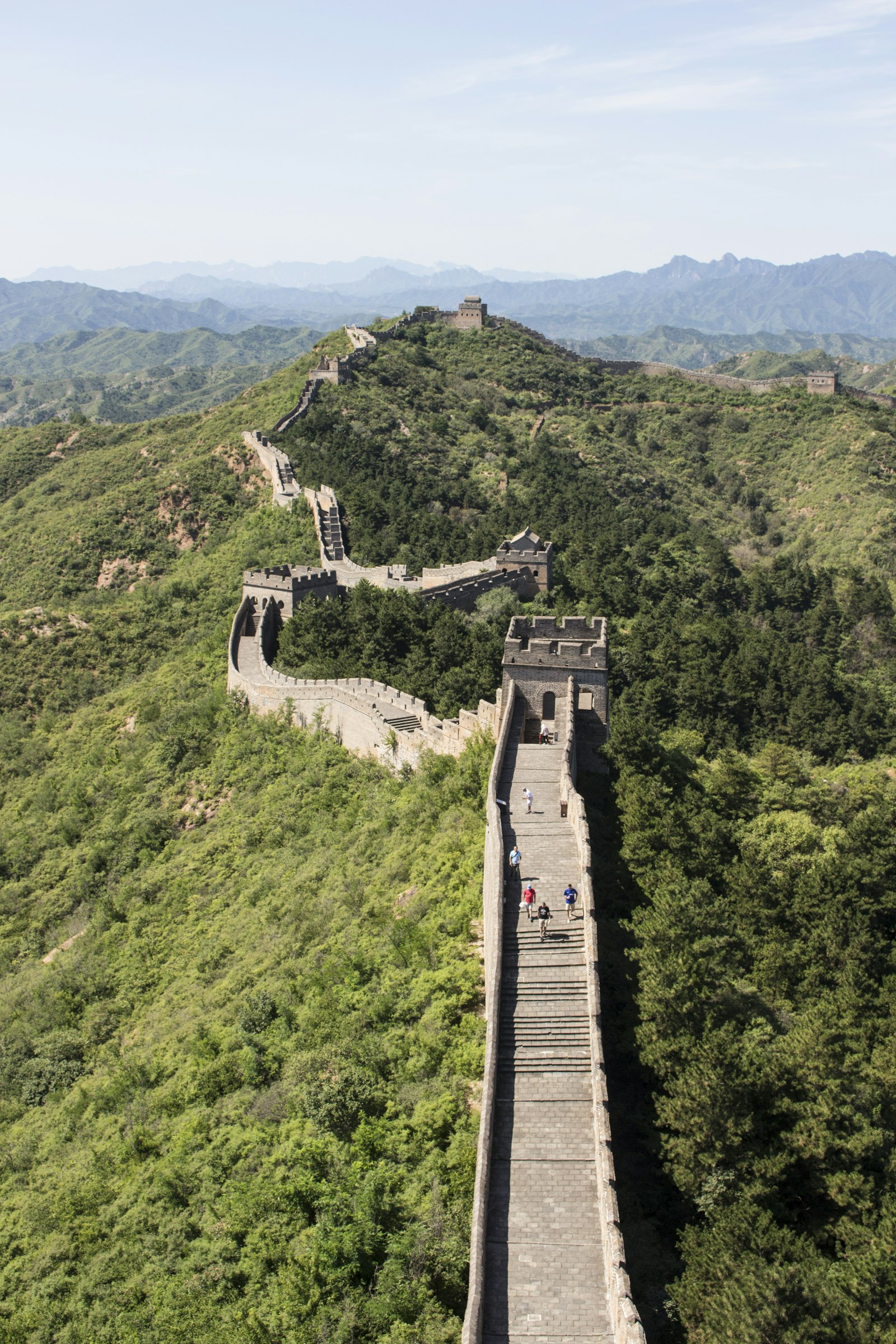 Abschnitt der Chinesischen Mauer, der sich über bewaldete Bergkämme zieht