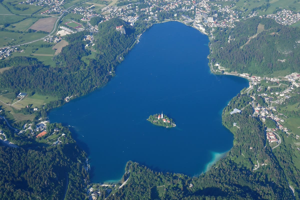 Türkisfarbener Bleder See mit Inselkirche vor Alpenkulisse