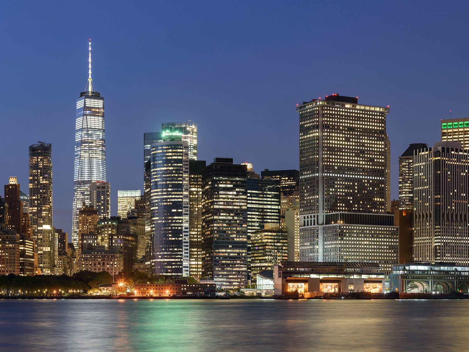 Skyline von Lower Manhattan über dem Wasser in der Abenddämmerung