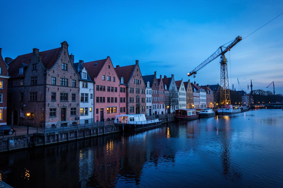 Historische Giebelhäuser an der Uferpromenade von Danzig zur blauen Stunde
