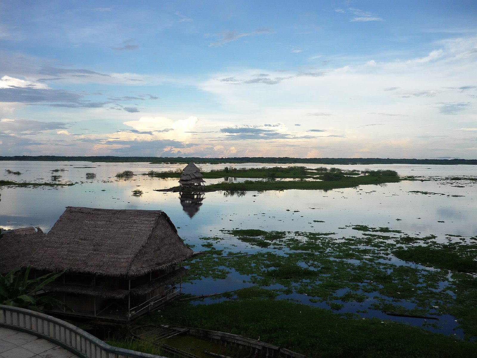 Amazonas-Lagune mit Holzhütte im Regenwald Perus bei Sonnenuntergang