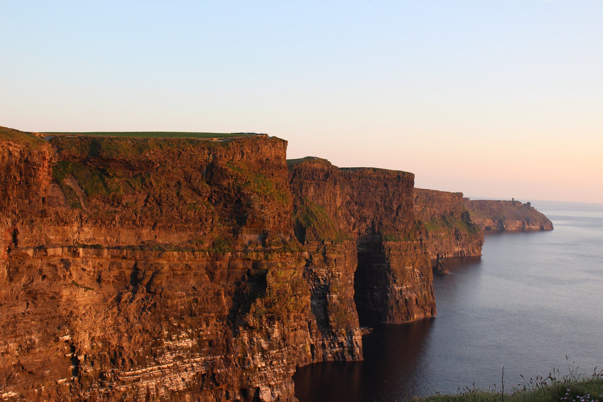 Die Cliffs of Moher in Irland über ruhiger See im Abendlicht